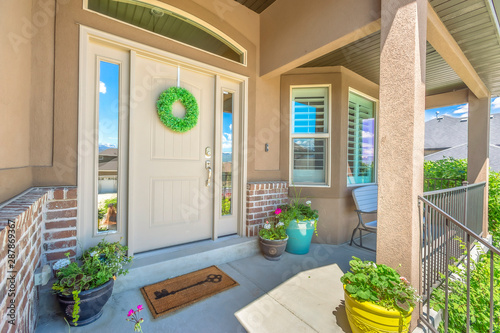 Front door with wreath transom window and sideligts at the facade of a home photo
