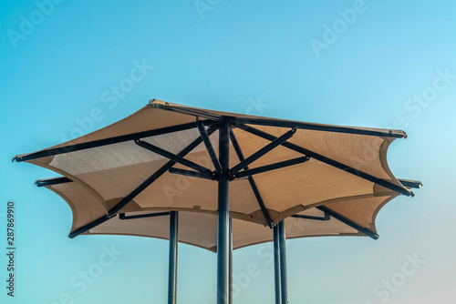 Close up view of playground umbrellas with light blue sky in the background