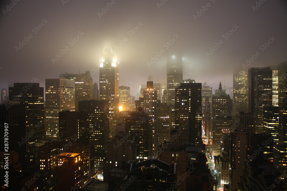 Φωτογραφία New York City landscape at night with lights building translucid by the fog