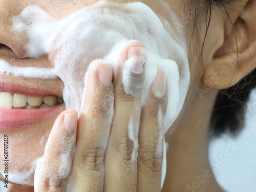Close up Asian woman smile and washing face by make bubble facial foam and cleansing her face skin