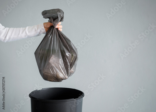 Obraz na plátně Person throwing out garbage in plastic bag