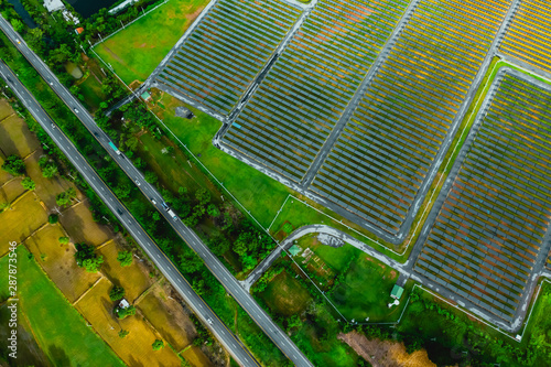 Aerial view traffic asphalted parallel road in countryside landscape with fields and solar cell panel 