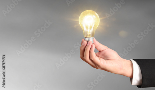 Hand of holding illuminated light bulb photo