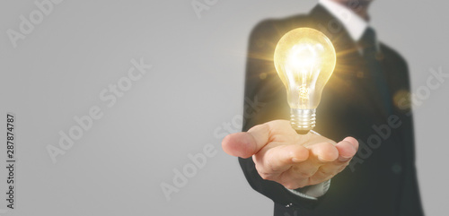 Hand of holding illuminated light bulb