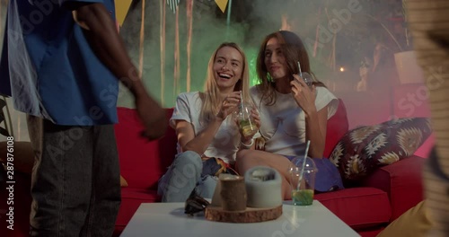 Wallpaper Mural Young man sit down to the girls get to know each other spend time together relax drink cocktail on night party beautiful modern smile feel happy fun party camera cellphone excitement slow motion Torontodigital.ca