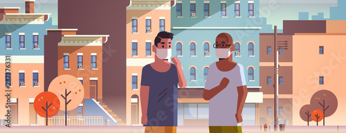 men wearing face masks toxic gas air pollution industry smog polluted environment concept mix race guys walking outdoor dirty smoke city buildings cityscape background portrait horizontal