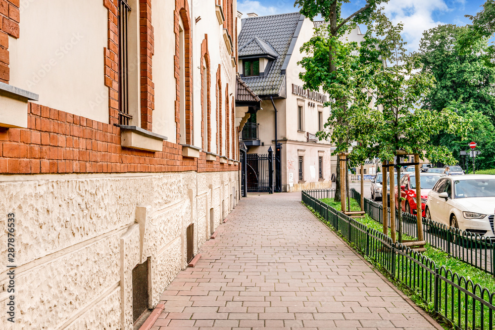 Obraz premium KRAKOW, POLAND - MAY 25, 2019: Old tenements and city park