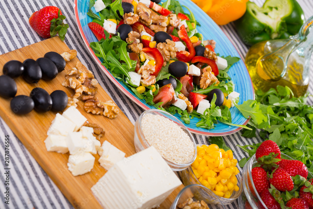 Plate with ready-made salad and its ingredients for recipe