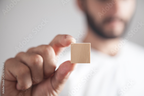 Man holding wooden empty cube.