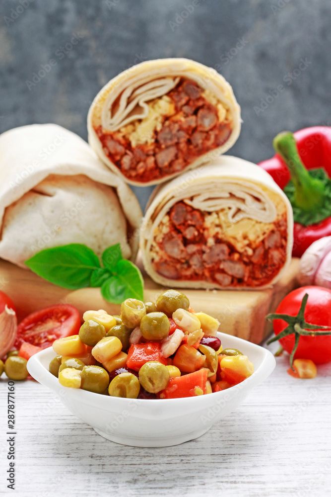 A burrito - mexican dish that consists of a flour tortilla with various ingredients.
