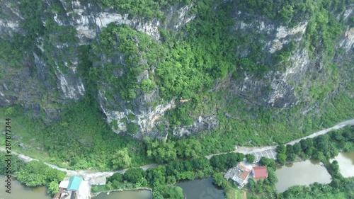 Drone footage over a lake near karst mountains, in Tam Coc, north Vietnam, fantastic Unesco World Heritage site and popular for tourists photo