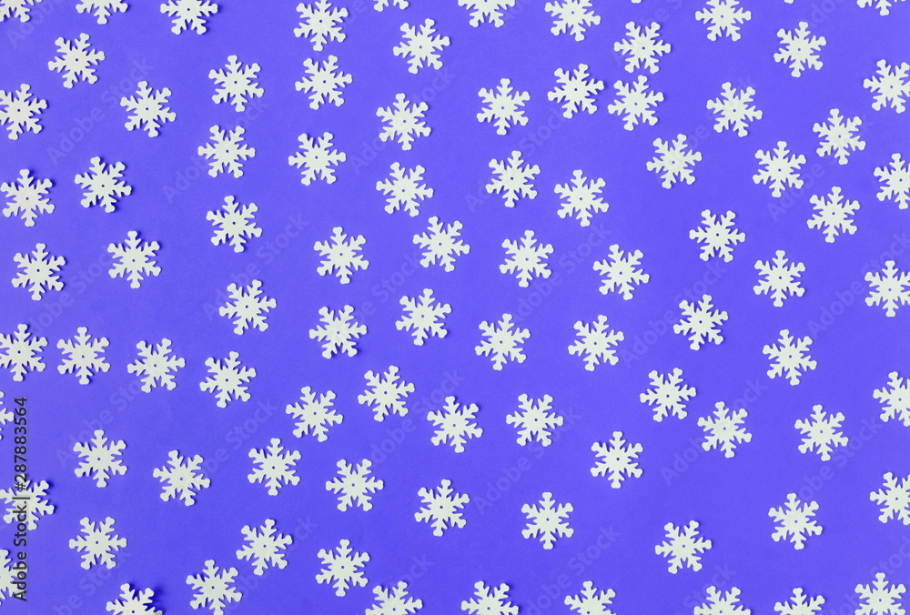 White snowflakes confetti pattern on blue color background. Minimal  holiday concept. Winter festive backdrop. Top view, flat lay