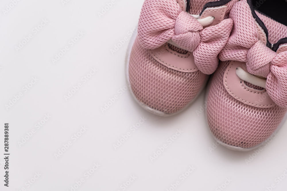 On a white background, pink baby sneakers, copy space On a white background, pink baby sneakers, copy space