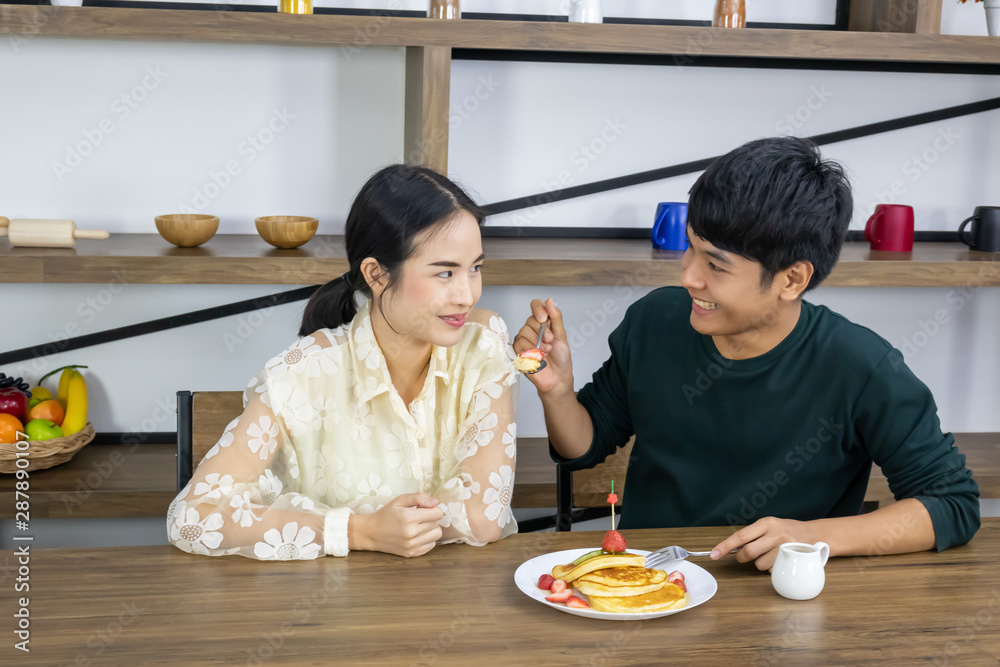 Men are feeding strawberry pies to women.
