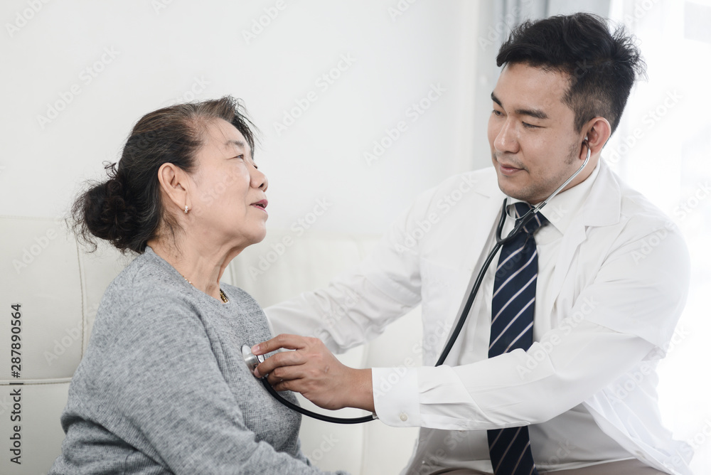 Asian doctor checking up his patient old woman in office. Asian doctor checking up his patient old woman in office.