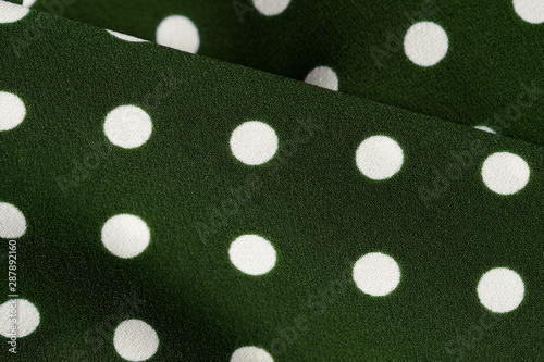 Green and white polka dot textile close up. Abstract background