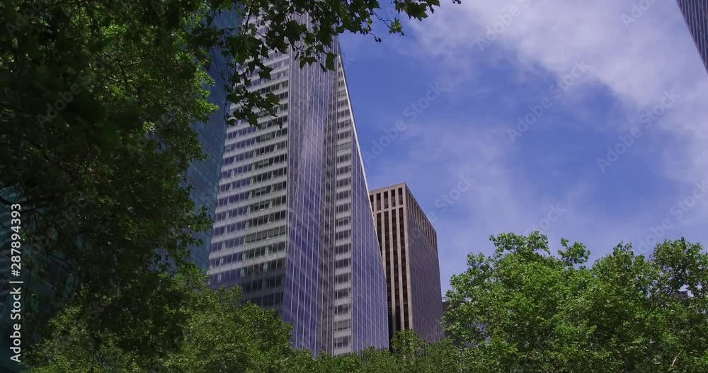 View of modern skyscrapers above the green trees of the Bryant Park in Manhattan, New York. View of modern skyscrapers above the green trees of the Bryant Park in Manhattan, New York.