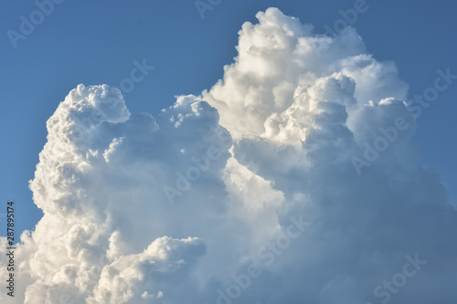 Fluffy white clouds in a blue sky on a sunny day.
