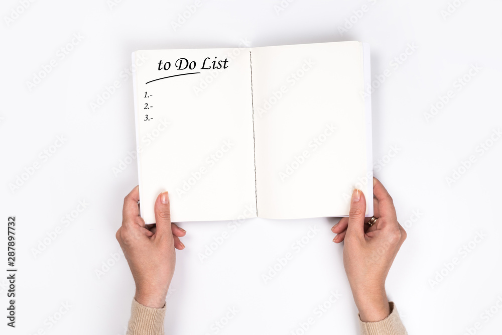 To Do List Concept - 2020 number and text on notepad. Woman's hands with perfect manicure holding notepad as mockup for your design. White background, flat lay style. To Do List Concept - 2020 number and text on notepad. Woman's hands with perfect manicure holding notepad as mockup for your design. White background, flat lay style.