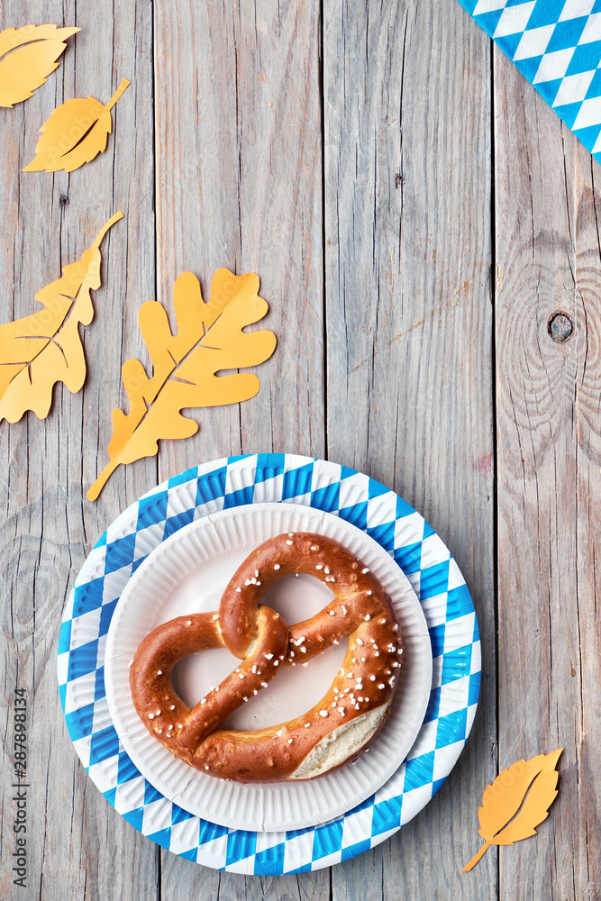 Oktoberfest, flat lay on rustic wooden table with pretzel and Autumn decorations Oktoberfest, flat lay on rustic wooden table with pretzel and Autumn decorations