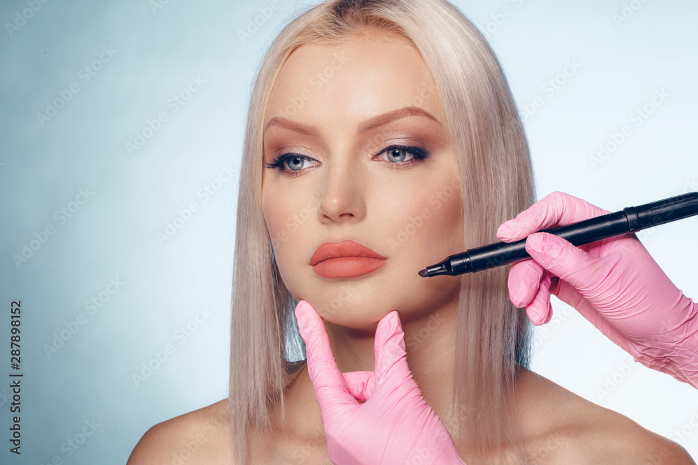 Woman face and doctor hands with pencil. Plastic surgery concept