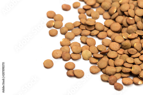 Isolated stack of uncooked lentils on white background from above.