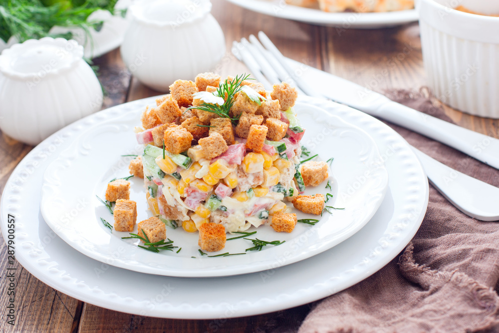 Salad with smoked sausage and crackers on a white plate in a portion serving, horizontal Salad with smoked sausage and crackers on a white plate in a portion serving, horizontal