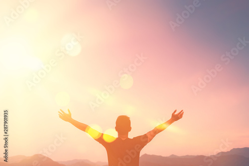 Copy space of man rise hand up on top of mountain and sunset sky abstract background. photo