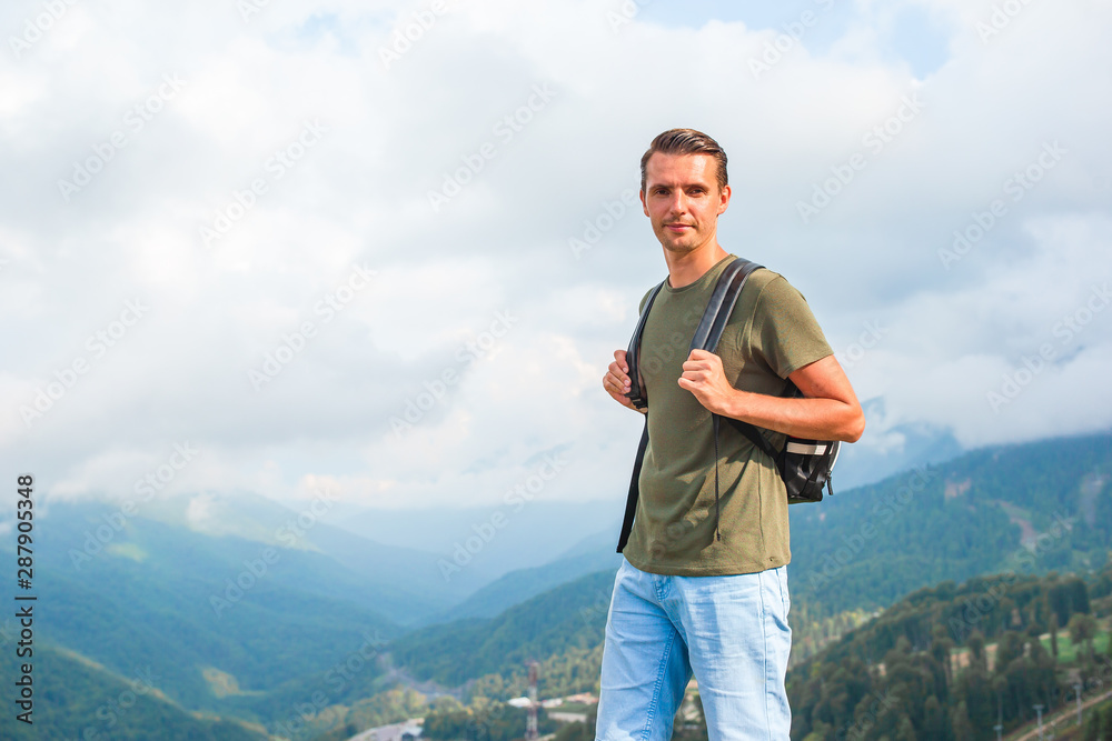 Tourist man in mountains in the background of fog