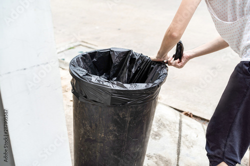 Asian Thai housewife is prepare the garbage plastic black bag at the fron of her house. photo