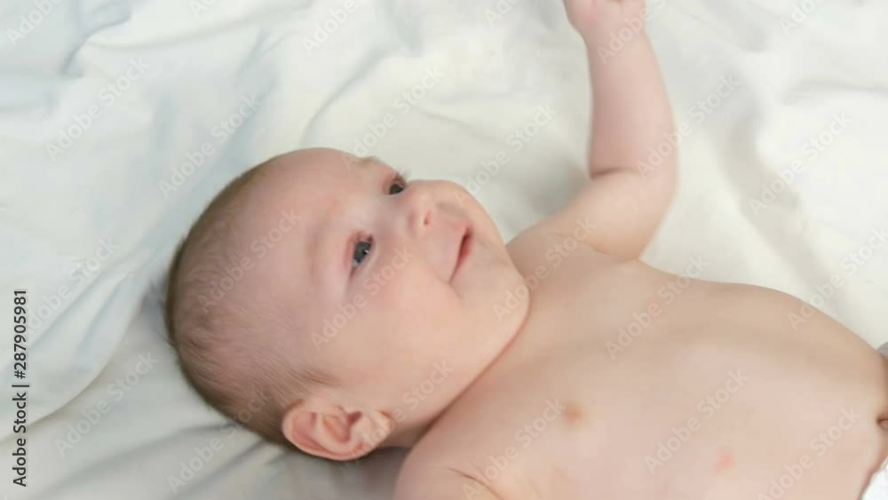 Portrait of beautiful funny little newborn baby of two months lying on a white bed Portrait of beautiful funny little newborn baby of two months lying on a white bed