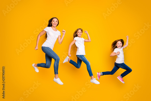 Full body photo of three ladies jumping high hurrying sale shopping wear casual clothes isolated yellow background
