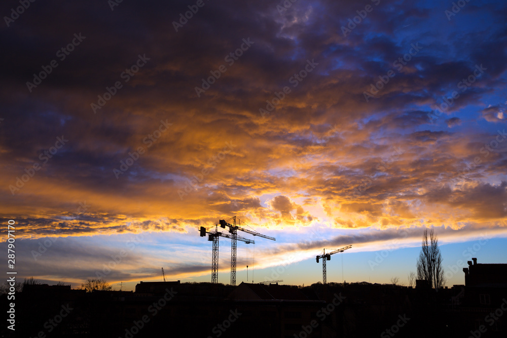 tower cranes against a stormy sky tower cranes against a stormy sky