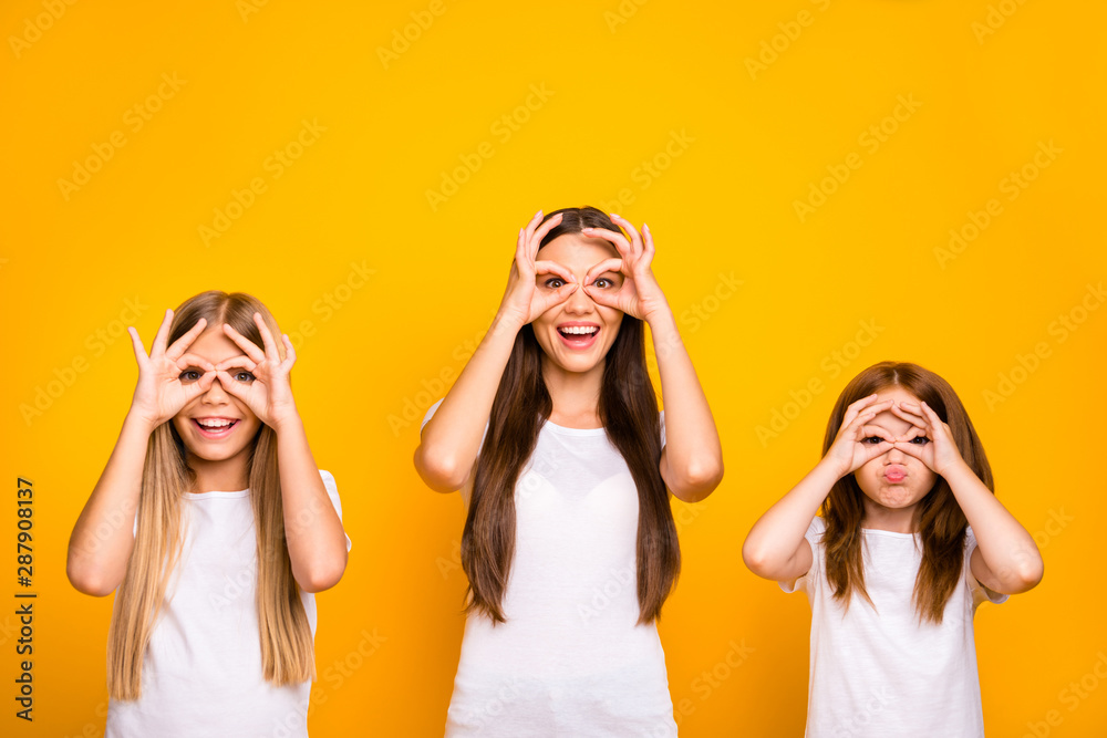 Funny three sister ladies holding hands in okey symbols near eyes like specs wear casual outfit isolated yellow background Funny three sister ladies holding hands in okey symbols near eyes like specs wear casual outfit isolated yellow background