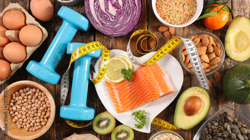 selection of diet food, salmon with dumbbell and healthy food