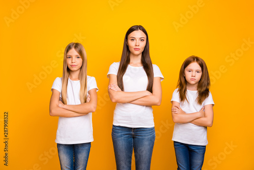 Photo of three sister ladies attentively listening not smiling wear casual white t-shirts isolated yellow background