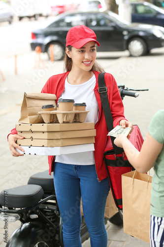 Woman paying courier for fo...