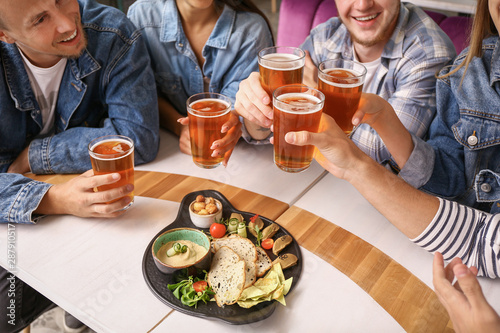 Friends drinking fresh beer in pub