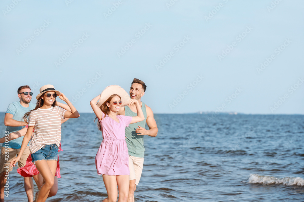 Happy friends running on sea beach at resort Happy friends running on sea beach at resort