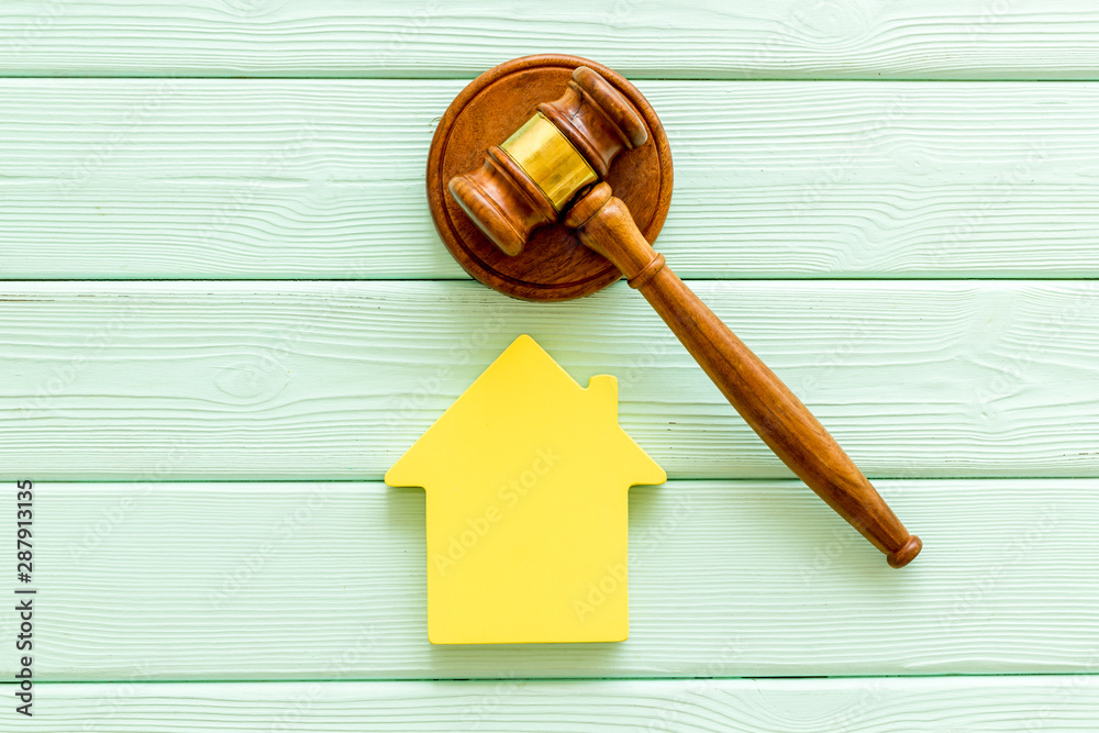 Inheritance of the house concept with figure and gavel on mint green wooden background top view Inheritance of the house concept with figure and gavel on mint green wooden background top view