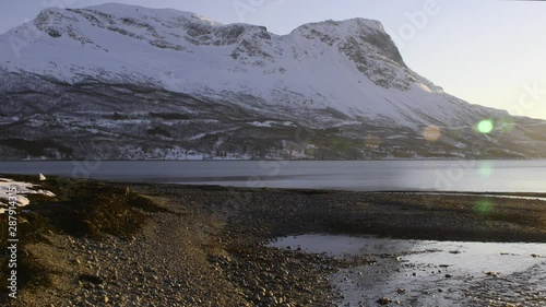 Mountain view over the north Norwegian arctic ocea fjord. Very scenery view with sun flares and clean stream. photo