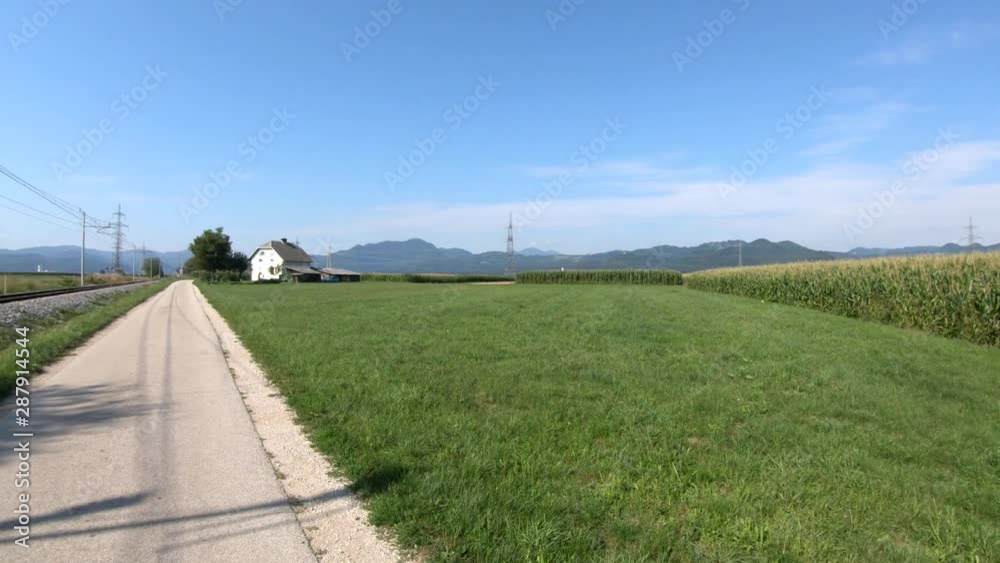 4K Forward moving right pan view train tracks near countryside road on bright day 4K Forward moving right pan view train tracks near countryside road on bright day