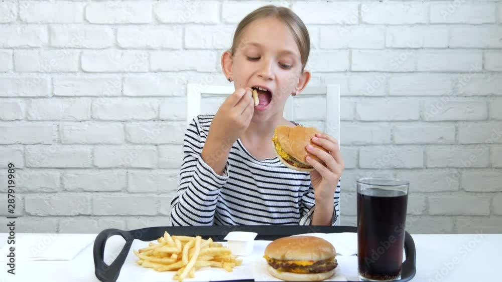 Child Eating Fast Food, Kid Eats Hamburger in Restaurant, Girl Drinking Juice Child Eating Fast Food, Kid Eats Hamburger in Restaurant, Girl Drinking Juice