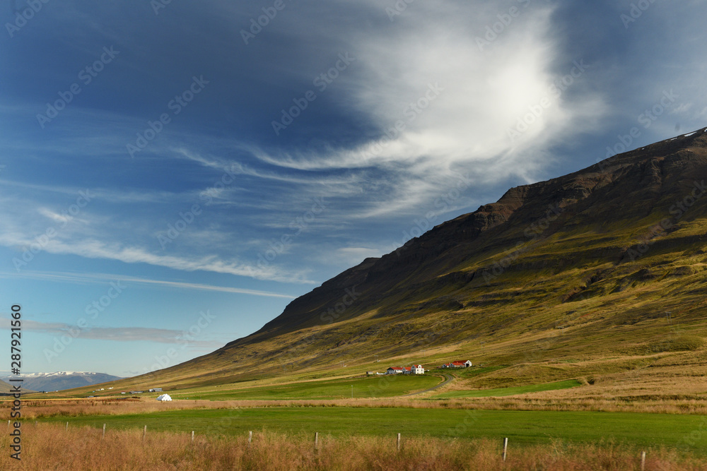 Green mountains, hills, vast expanses of sparsely populated landscapes, small houses of local residents in a green valley. The traditional look. Iceland.