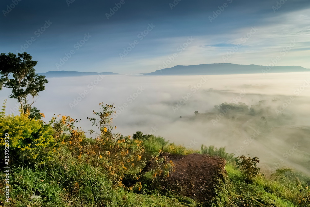 Mountain view morning of forest and top hill around with ocean of mist with cloudy sky background, sunrise at Khao Takhian Ngo, Khao Kho, Phetchabun, Thailand.