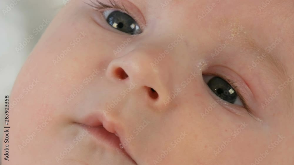 Portrait of beautiful funny little newborn baby of two months lying on a white bed Portrait of beautiful funny little newborn baby of two months lying on a white bed