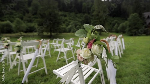 Wedding ceremony. White chairs on the grass photo