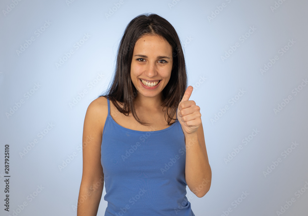 Portrait of pretty teenager making thumbs up gestures feeling happy and successful Portrait of pretty teenager making thumbs up gestures feeling happy and successful
