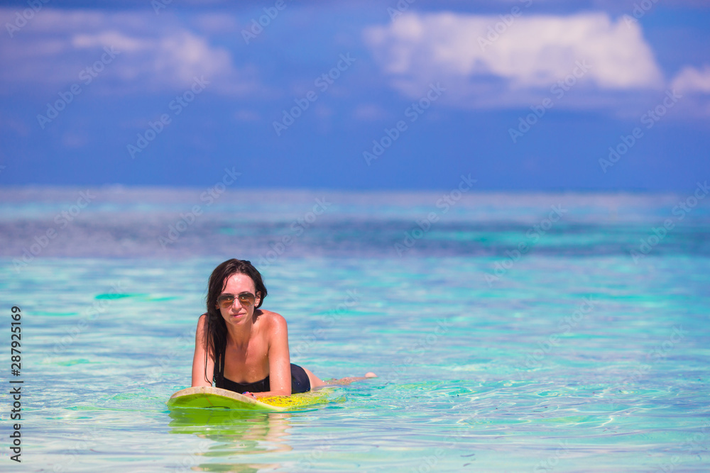Young surfer woman surfing during beach vacation