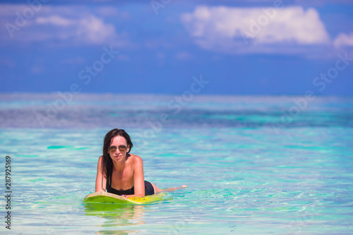 Young surfer woman surfing during beach vacation